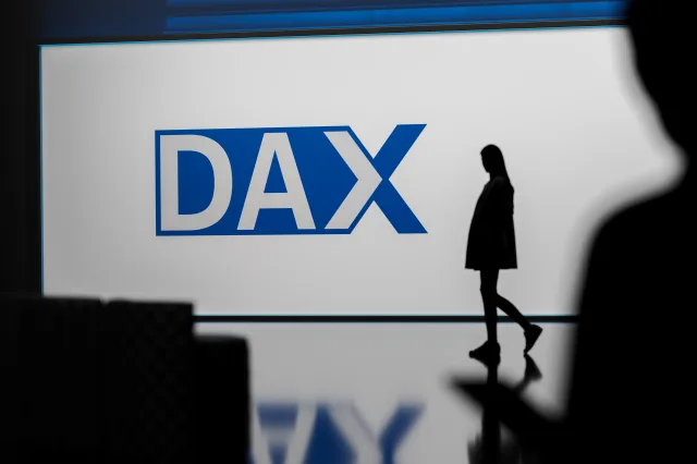 Jemand geht vor dem Dax-Logo vorbei.