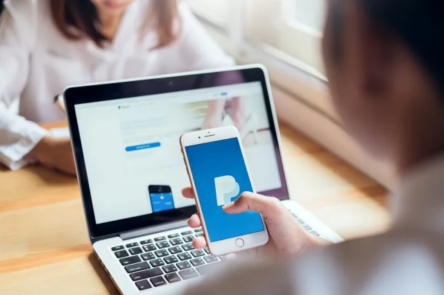 Jemand nutzt Paypal auf seinem Smartphone