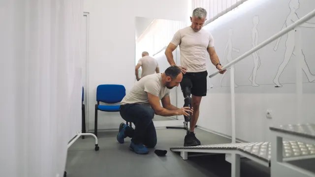 Jemand gewöhnt sich an eine Prothese