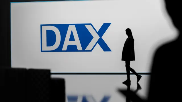 Jemand geht vor dem Dax-Logo vorbei.