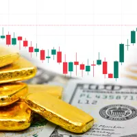 Goldbarren sind vor einem Kurschart zu sehen.