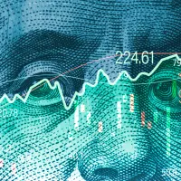 Ein Aktienkurs ist vor einem Dollar-Schein zu sehen.
