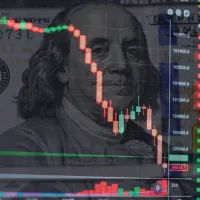 Ein Kurschart vor einer Dollar-Note.
