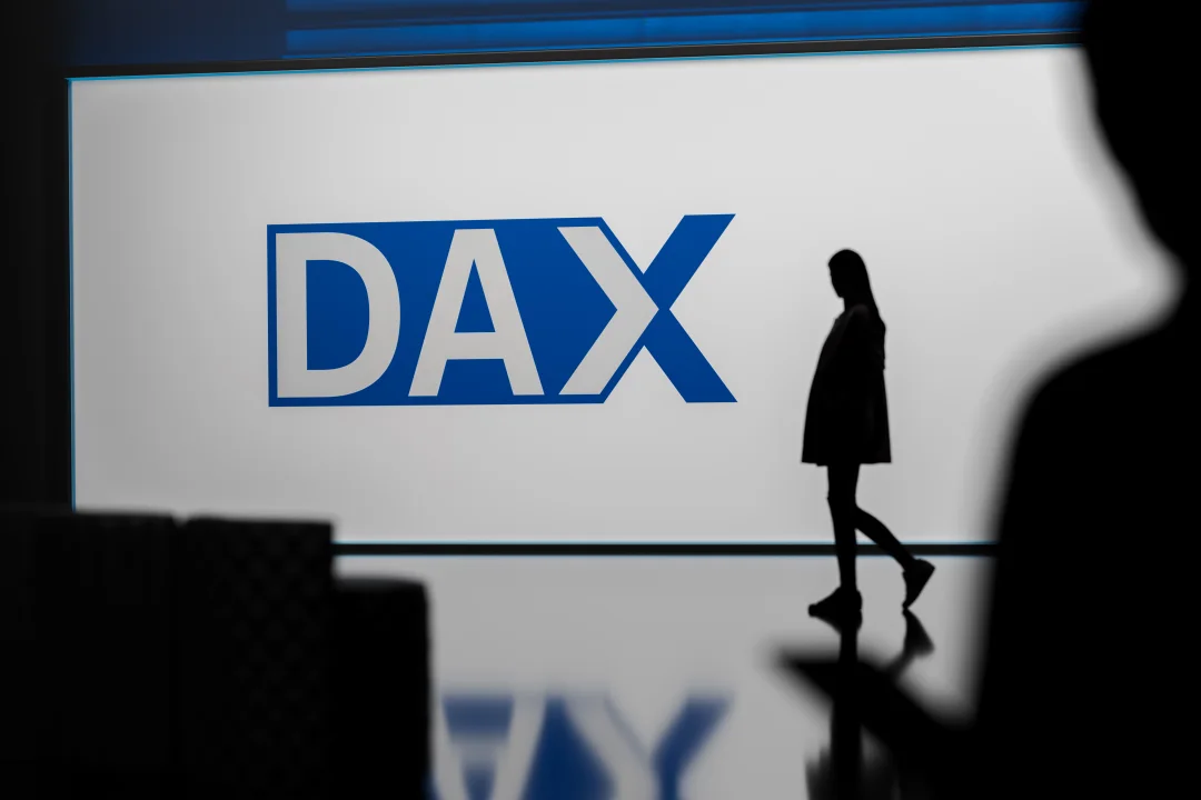 Jemand geht vor dem Dax-Logo vorbei.