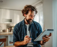 Ein Mann handelt online über ein Tablet.