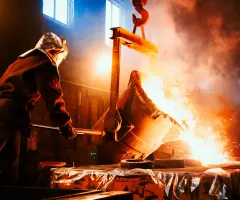 Die Arbeitnehmer arbeiten im Metallurgiewerk. Das flüssige Metall wird in Formen gegossen. Arbeiter, der die Metallschmelze in Öfen steuert.