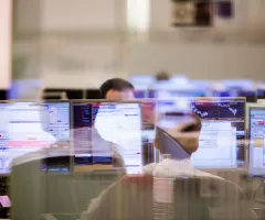 Jemand analysiert Kursdaten am Computer.