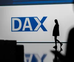 Jemand geht vor dem Dax-Logo vorbei.
