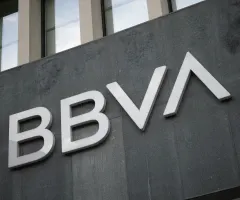 Zu sehen ist das Logo der spanischen Großbank BBVA an einer grauen Fassade eines modernen Bürogebäudes.