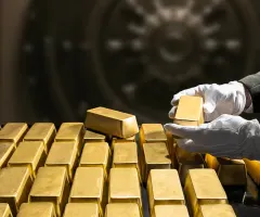 Jemand verstaut Goldbarren in einem Tresor.