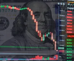 Ein Kurschart vor einer Dollar-Note.
