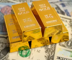 Goldbarren auf Dollar-Scheinen sind zu sehen.