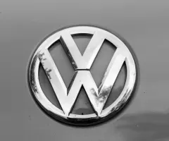 Volkswagen-Emblem auf grauer Karosserie eines Fahrzeugs