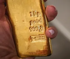 Jemand hält einen Goldbarren.